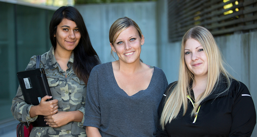 three female students holding books